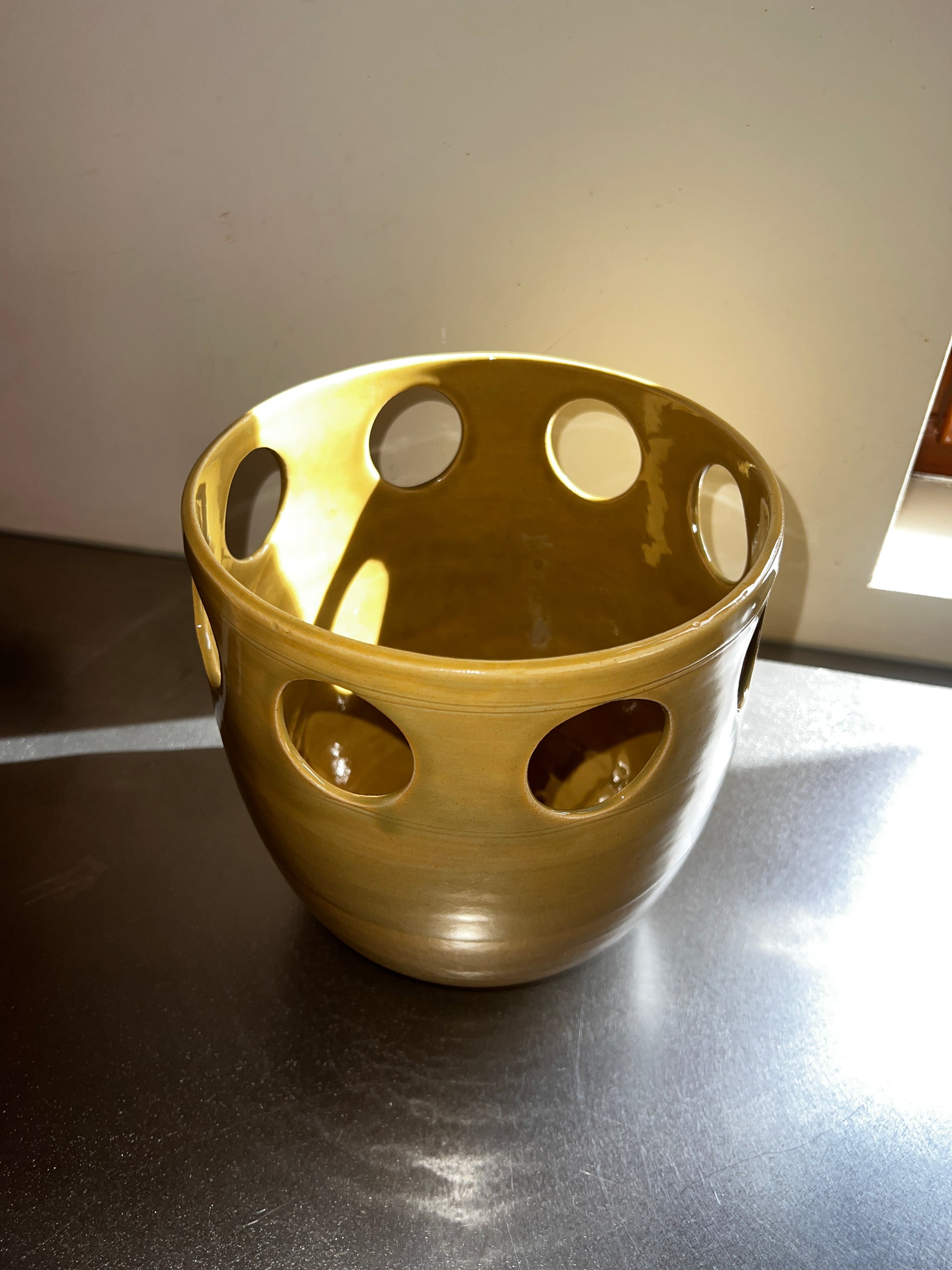 View into the glossy Goldgreen interior of the openwork ceramic vase